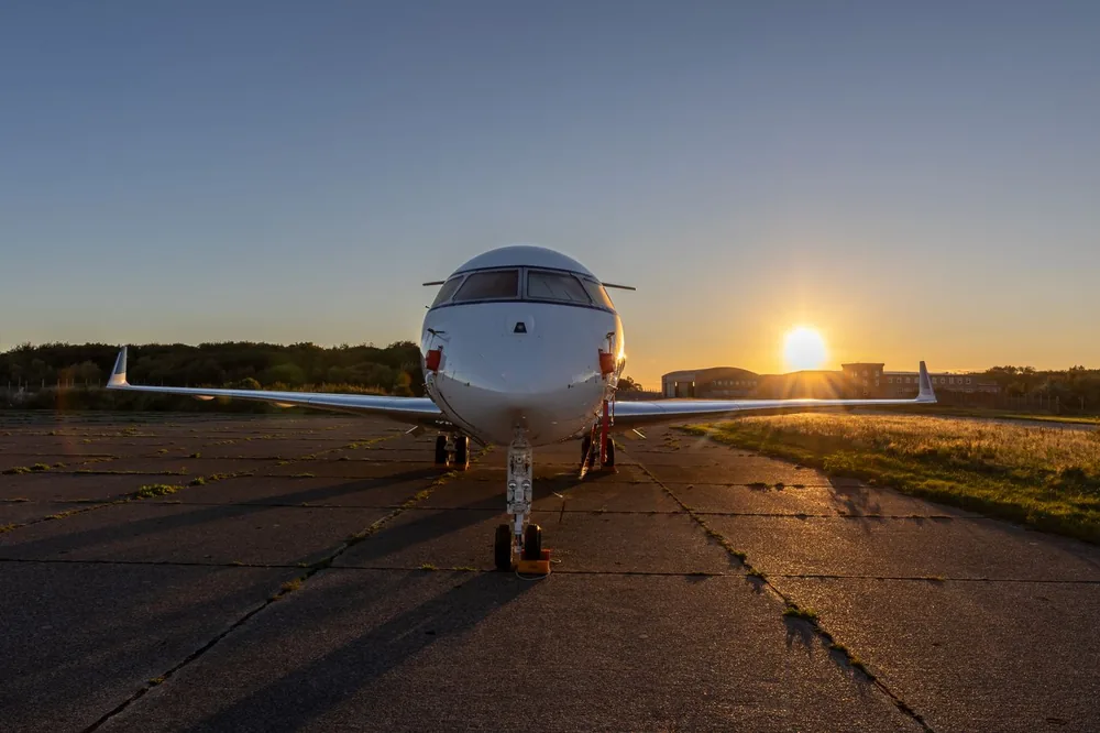 Private aircraft viewed head-on beneath a sunset sky