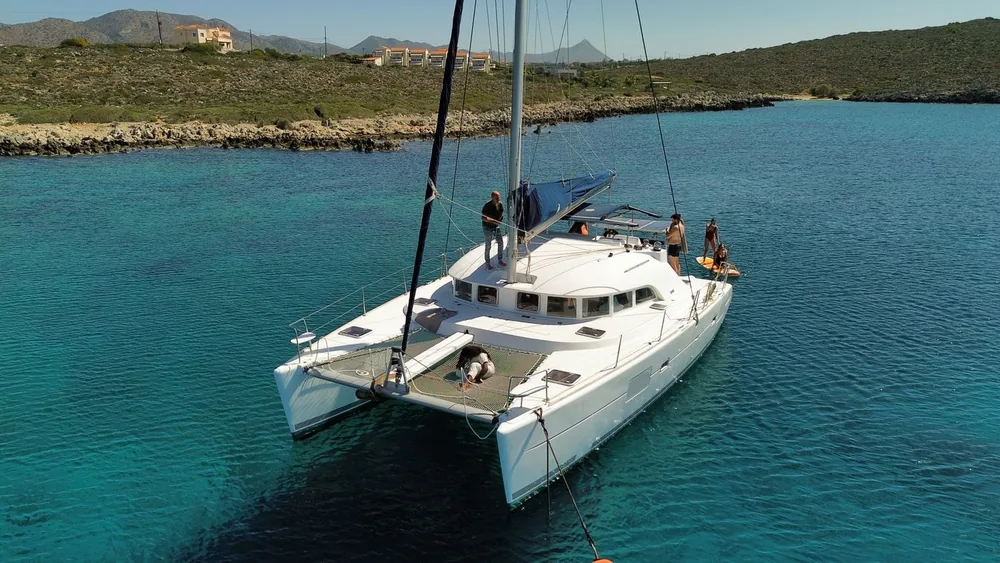 White sailing catamaran at anchor in clear blue water