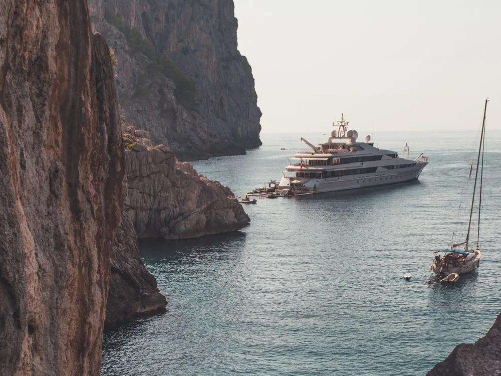Large white motor yacht on coastal water